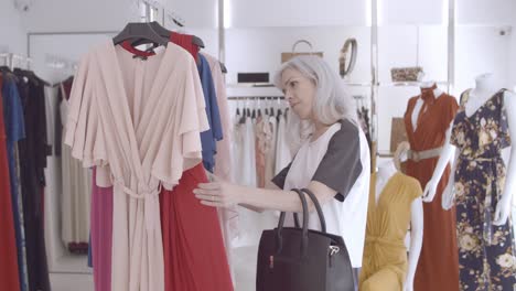 focused shop customer browsing clothes on rack