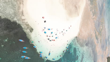 Vista-Aérea-De-Barcos-En-Las-Aguas-Turquesas-De-Zanzíbar-Y-Gente-Disfrutando-Del-Clima-En-Un-Banco-De-Arena.