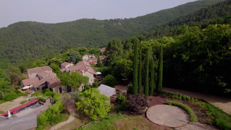 rustic villa in between forest hills in the branoux-les-taillades french countryside, aerial dolly left approach shot