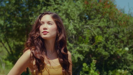 cute girl posing on green park closeup. asian woman standing on sunlight outdoor