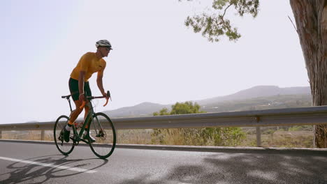 Un-Hombre-Monta-Su-Bicicleta-De-Carretera-Por-Una-Carretera-Vacía-Durante-Las-Horas-De-La-Mañana,-Haciendo-Ejercicio-Al-Aire-Libre.-Se-Transmite-La-Idea-De-Los-Deportes-Extremos,-Todo-Capturado-En-Cámara-Lenta.