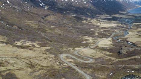 Drone-flight-over-curvy-road-into-valley-and-Fjord-on-Iceland