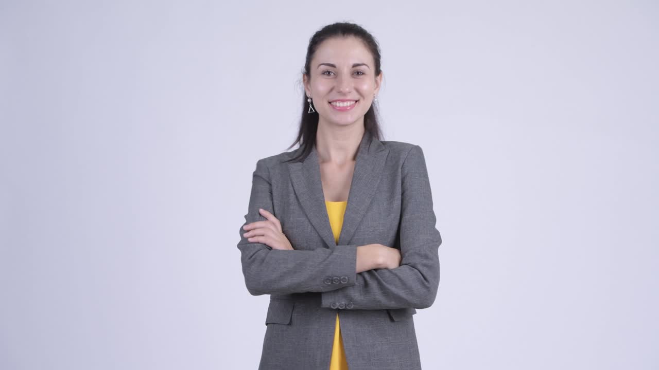 Happy young beautiful businesswoman with arms crossed