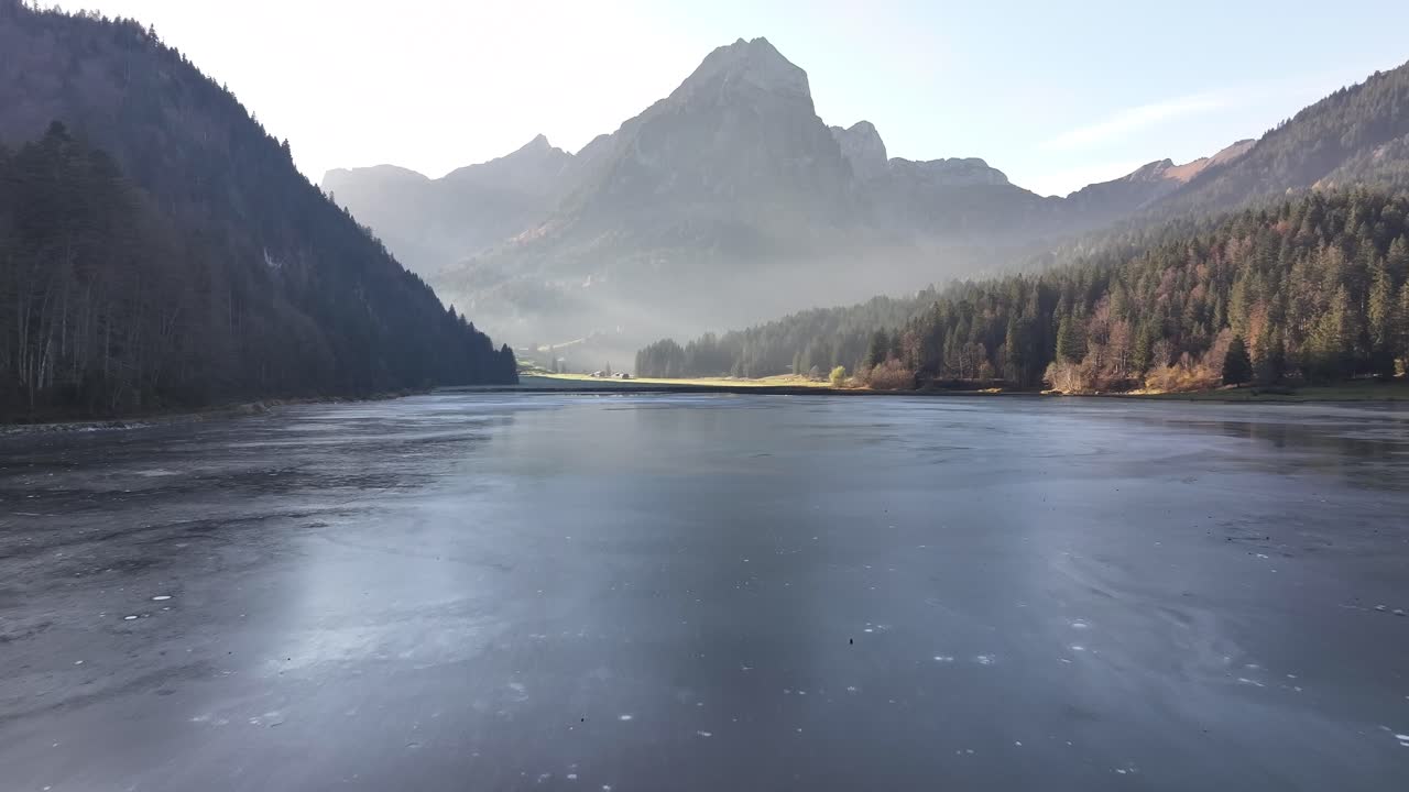 얼어붙은 오버시 호수, 네펠스, 글라루스, 스위스, 웅장한 눈 인 산꼭대기에 둘러싸인 드론 영상.
