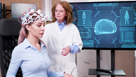 Female-scientist-checking-the-brain-activity-of-her-patient