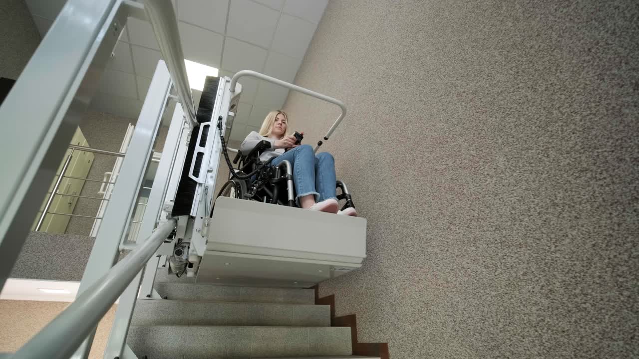 A girl in a wheelchair effortlessly ascends the stairs using a stair lift.