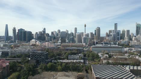 Aerial-shot-of-Sydney-City-center-in-the-morning,-drone-moving-up-over-CBD-revealing-the-beautiful-skyscrapers