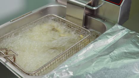 freidora comercial con alimentos en progreso