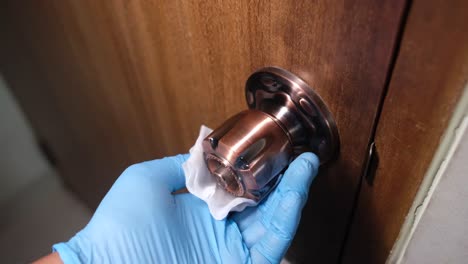 cleaning a door handle with gloves