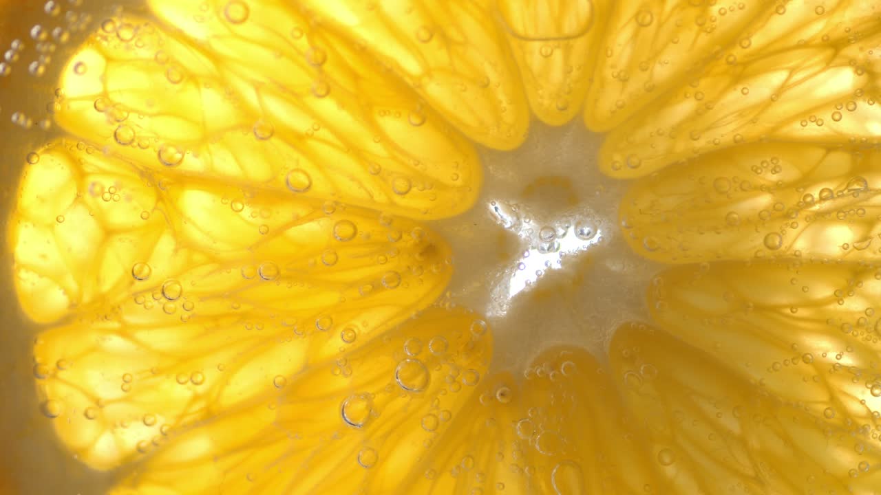 Fetta rotonda d'arancia sott'acqua con bolle d'aria