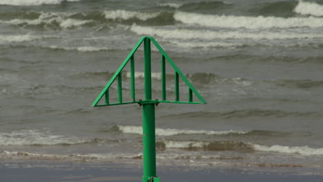 mid shot of a green groyne marker on saint bees beach. west lake district