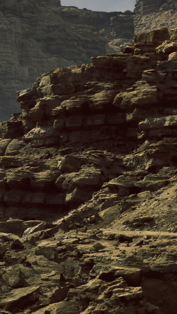 Maestose formazioni rocciose al tramonto che proiettano lunghe ombre nel canyon.