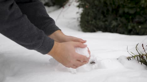 Kaukasische-Hände,-Die-Nach-Einem-Schneesturm-Im-Winter-Einen-Runden-Schneeball-Aus-Tiefschnee-Bilden