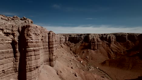 flying next to red sandstone cliffs in a desert wilderness