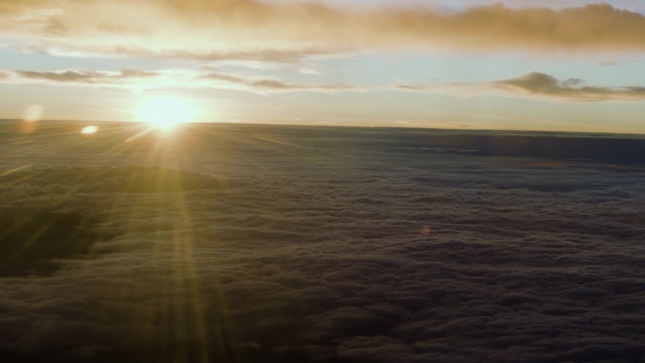 Aerial view from the window of an aircraft over an immense ocean of dense clouds
