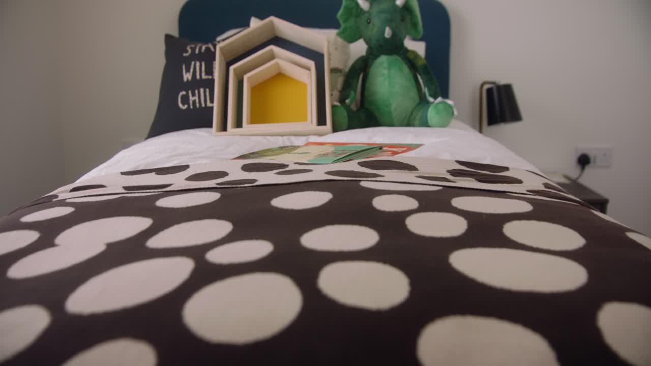 그 위에 다양한 장난감이 흩어져 있는 어린이 침대