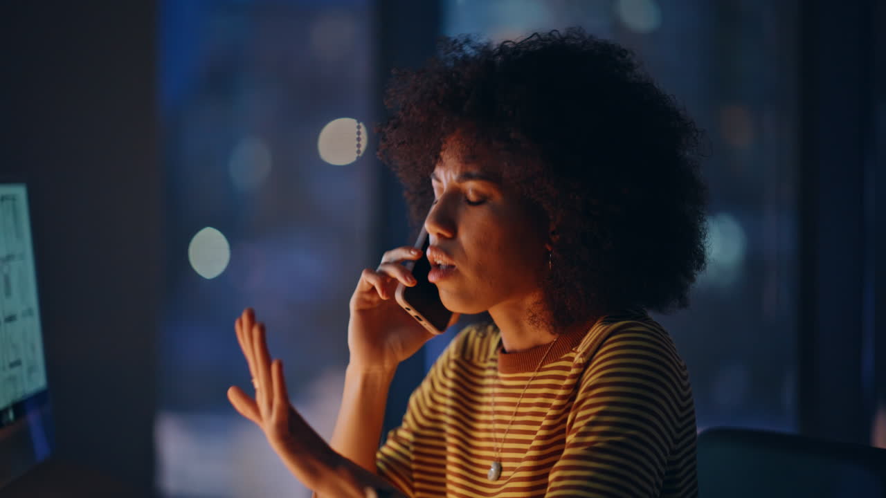 Worried woman talking cellphone holding project plan at night office closeup