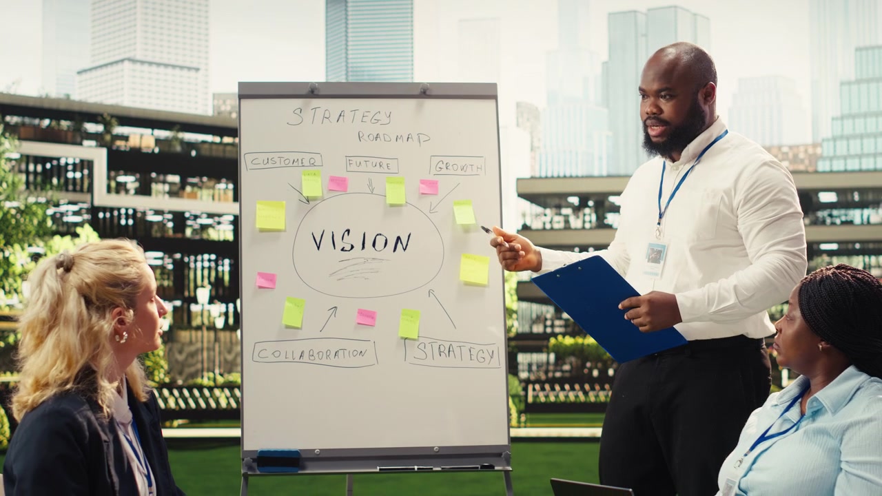 Black business presenter pointing at vision board with sticky notes