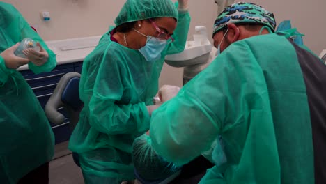 team of dentists preparing medical equipment to operate a patient