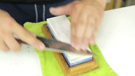 chef afilando su cuchillo de chef en una piedra de afilar, cómo hacer que un cuchillo esté afilado