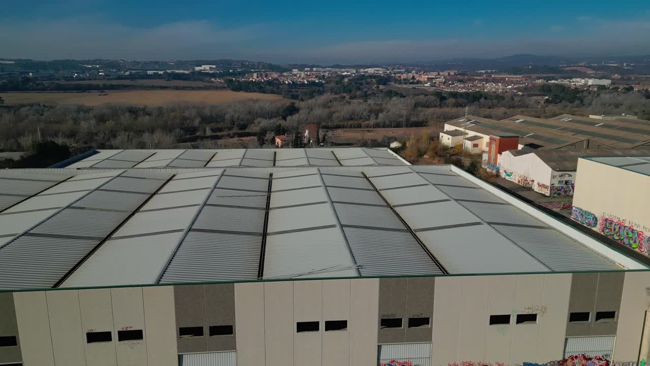 gran techo de almacén industrial con el paisaje de abrera, barcelona en el fondo, vista aérea