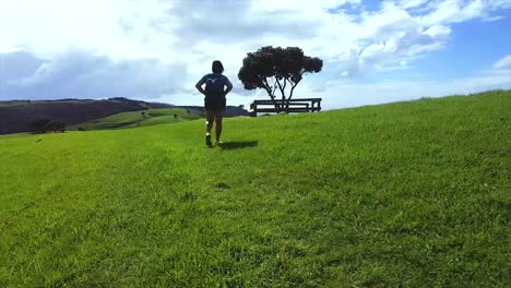 back view footage of a lady tramping on whangaparoa
