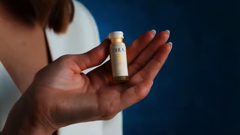 woman holding a small bottle of dhea supplement