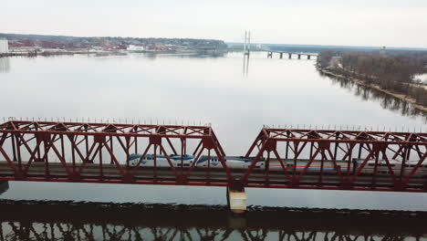 a passenger train crosses a drawbridge across the mississippi river near burlington iowa