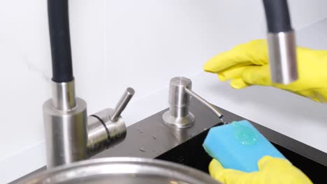 dishwashing concept a woman presses detergent onto a sponge close up
