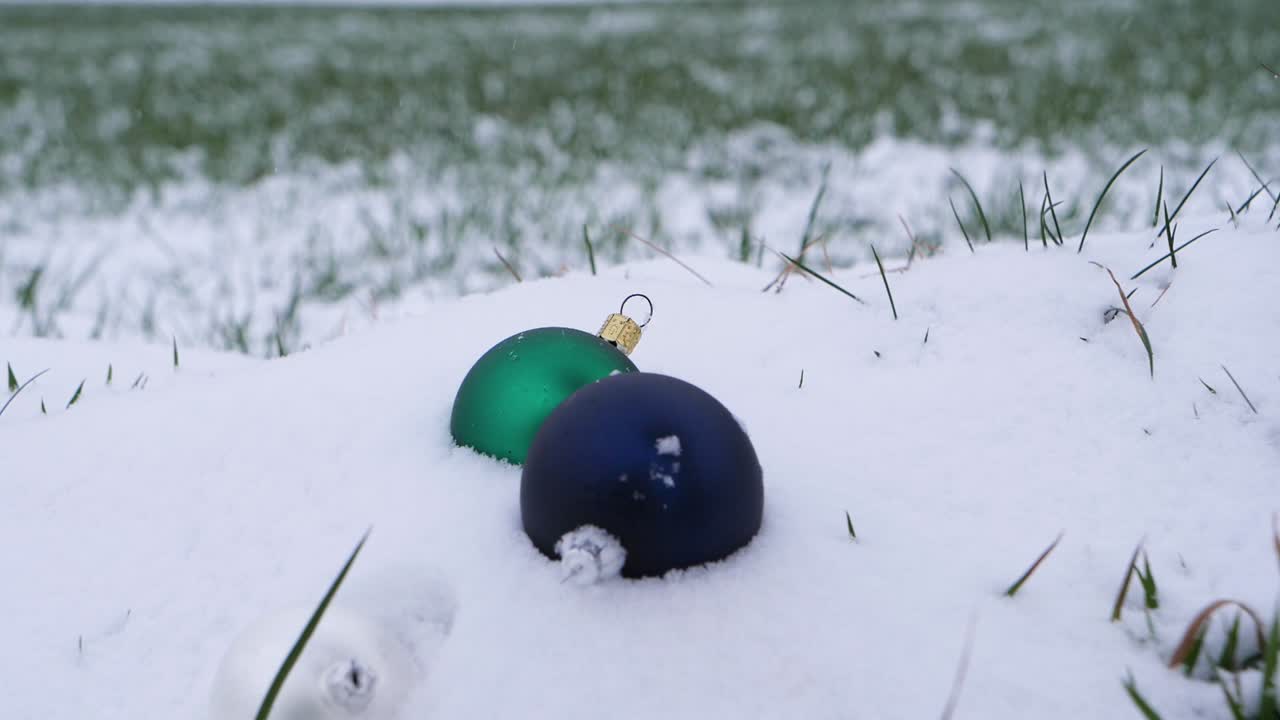 primer plano de bolas de navidad cayendo en la nieve al aire libre en la naturaleza durante el invierno