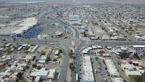 view from a drone flying still over the city of mexicali showing far away a monument of the mexican ex-president francisco zarco in the middle of a roundabout