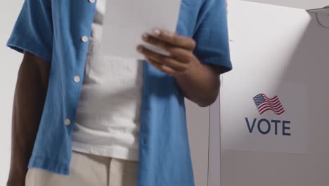 primer plano del hombre al lado de la cabina con la papeleta en las elecciones estadounidenses decidiendo cómo emitir su voto 2