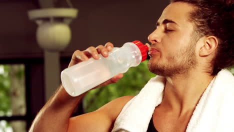 fit smiling man drinking water