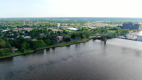 Slow-flight-down-over-river-alongside-an-old-truss-bridge