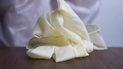 nurse in ppe protective suit dropping latex gloves on a table