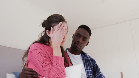 depressed diverse couple embracing and comforting each other at home, slow motion,copy space