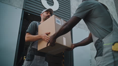 delivery workers exchanging a package at a warehouse loading dock