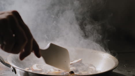 mushrooms being sautéed in a hot pan