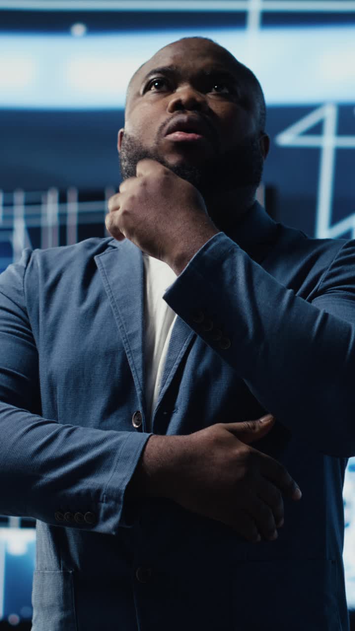 Thoughtful Man Looking at Data Screens in a Modern Tech Environment