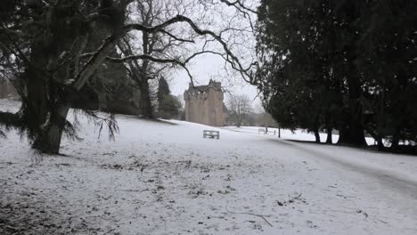 Castillo-De-Crathes-En-La-Nieve-Enmarcado-Por-Ramas-De-árboles.