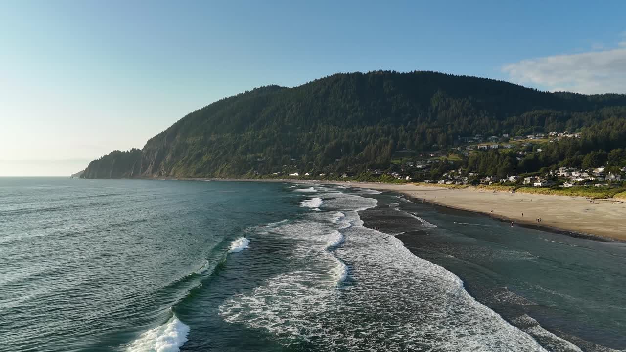 Luftfoto av Manzanita Beach. Strandgjester og hunder leker på stranden ved Oregonkysten.