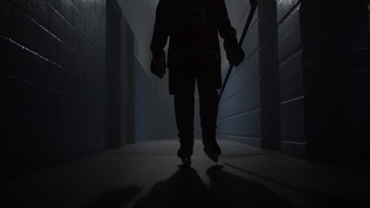 A closeup of a hockey player walking down the hallway in the arena for playing a game