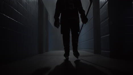 a closeup of a hockey player walking down the hallway in the arena for playing a game