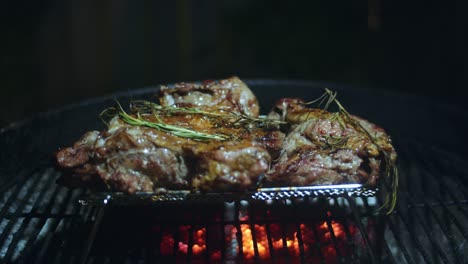 Wunderschönes,-Mit-Rosmarin-Und-Knoblauch-Bedecktes-Schmetterlingslamm-Ruht-Auf-Einem-Rost,-Während-Die-Kohlen-Im-Grill-Es-Perfekt-Garen