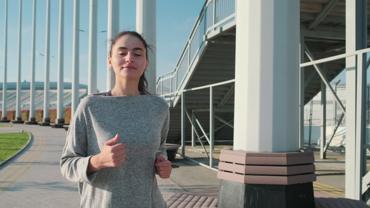 mujer corriendo en un parque cerca del estadio