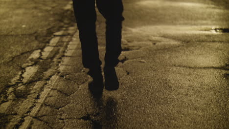 person wearing a hoodie entering a brightly lit tunnel at night