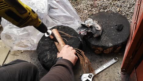 el hombre hace que el bricolaje casero falle divertido con el taladro de división de troncos que gira la madera y pierde el control