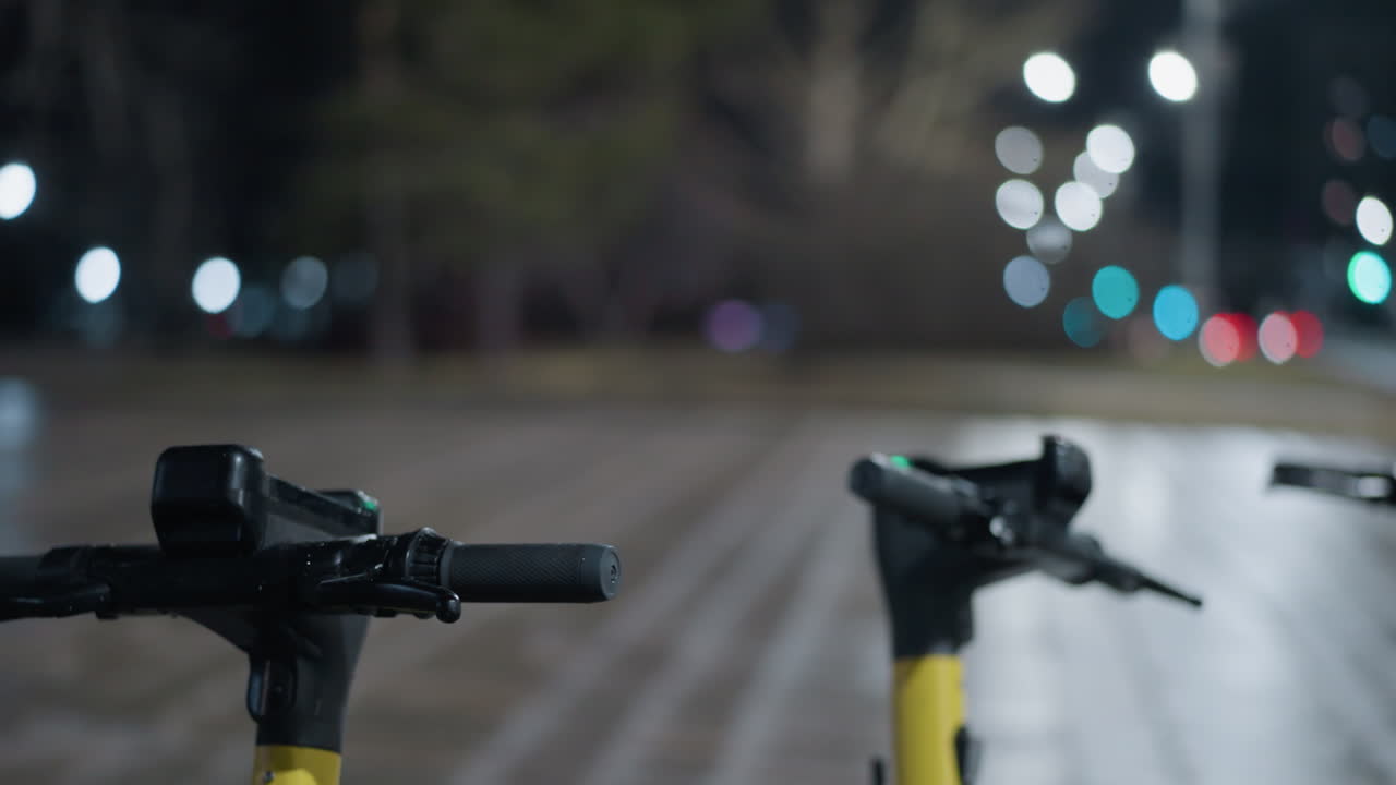 Close-up view of parked electric scooter bike handles with soft bokeh effects in the background, and blur view of a house