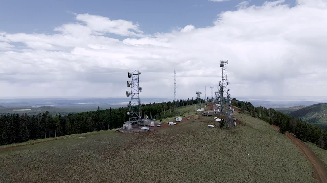 무성한 나무로 둘러싸인 애리조나 주 그린스 피크의 산 정상에 있는 통신 타워 - 공중 드론