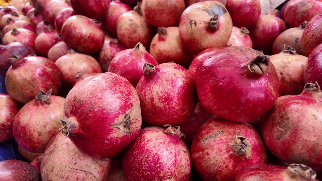 Vibrant Red Pomegranates on Display at a Fruit Market